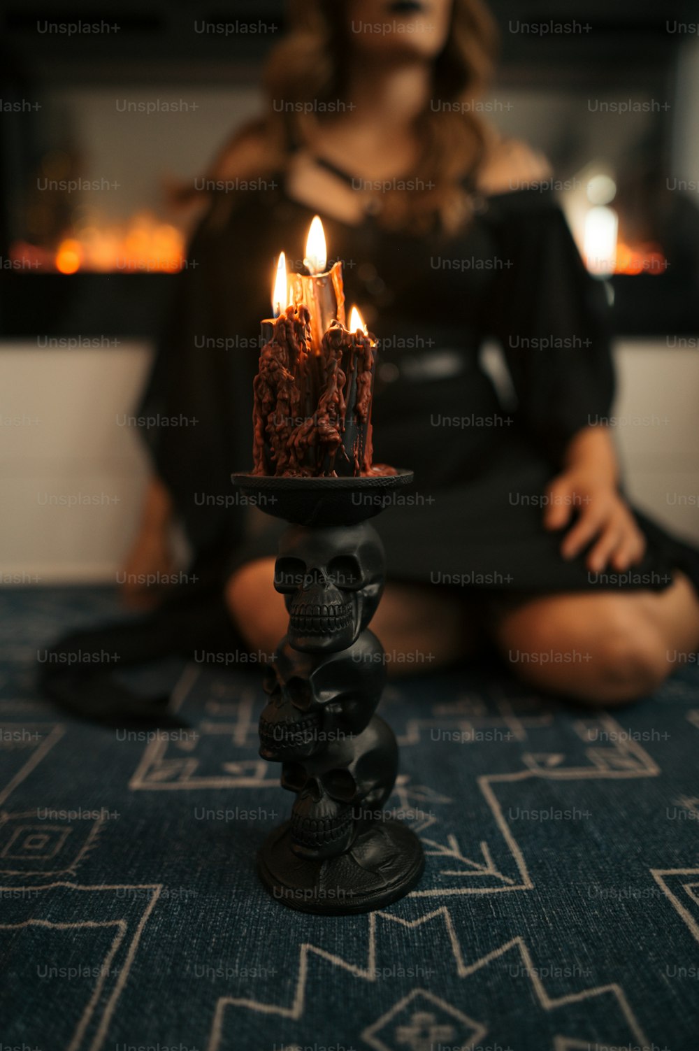 a woman sitting on the floor in front of a cake