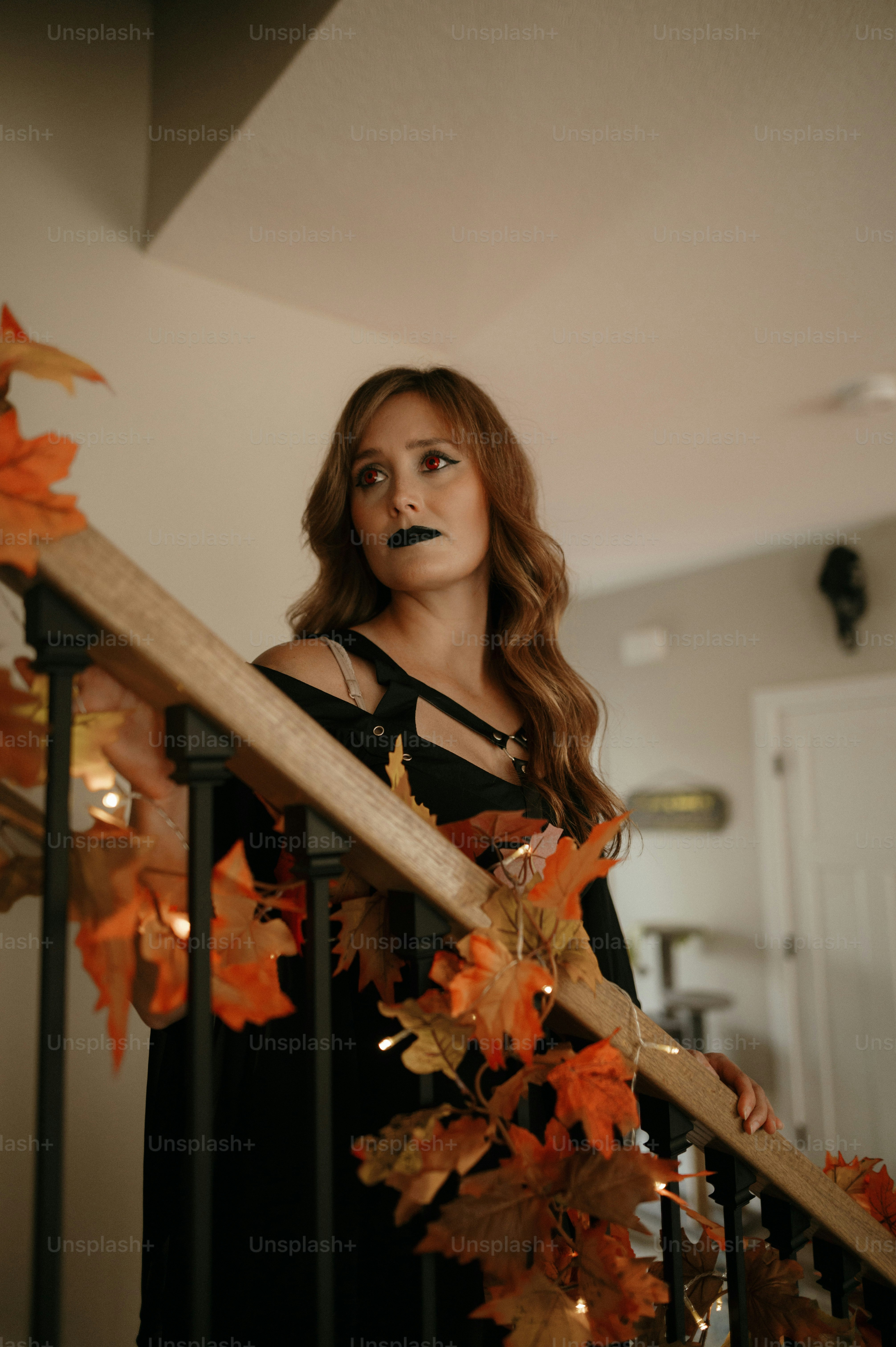 Una mujer con un vestido negro sostiene un bate