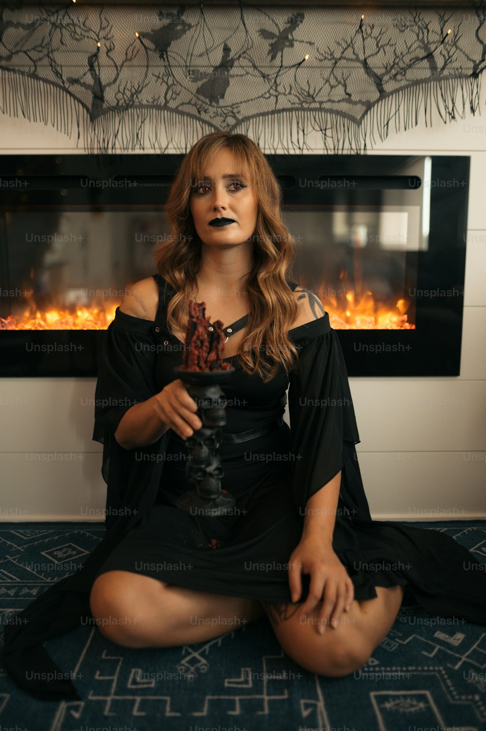 a woman sitting on the floor in front of a fire place