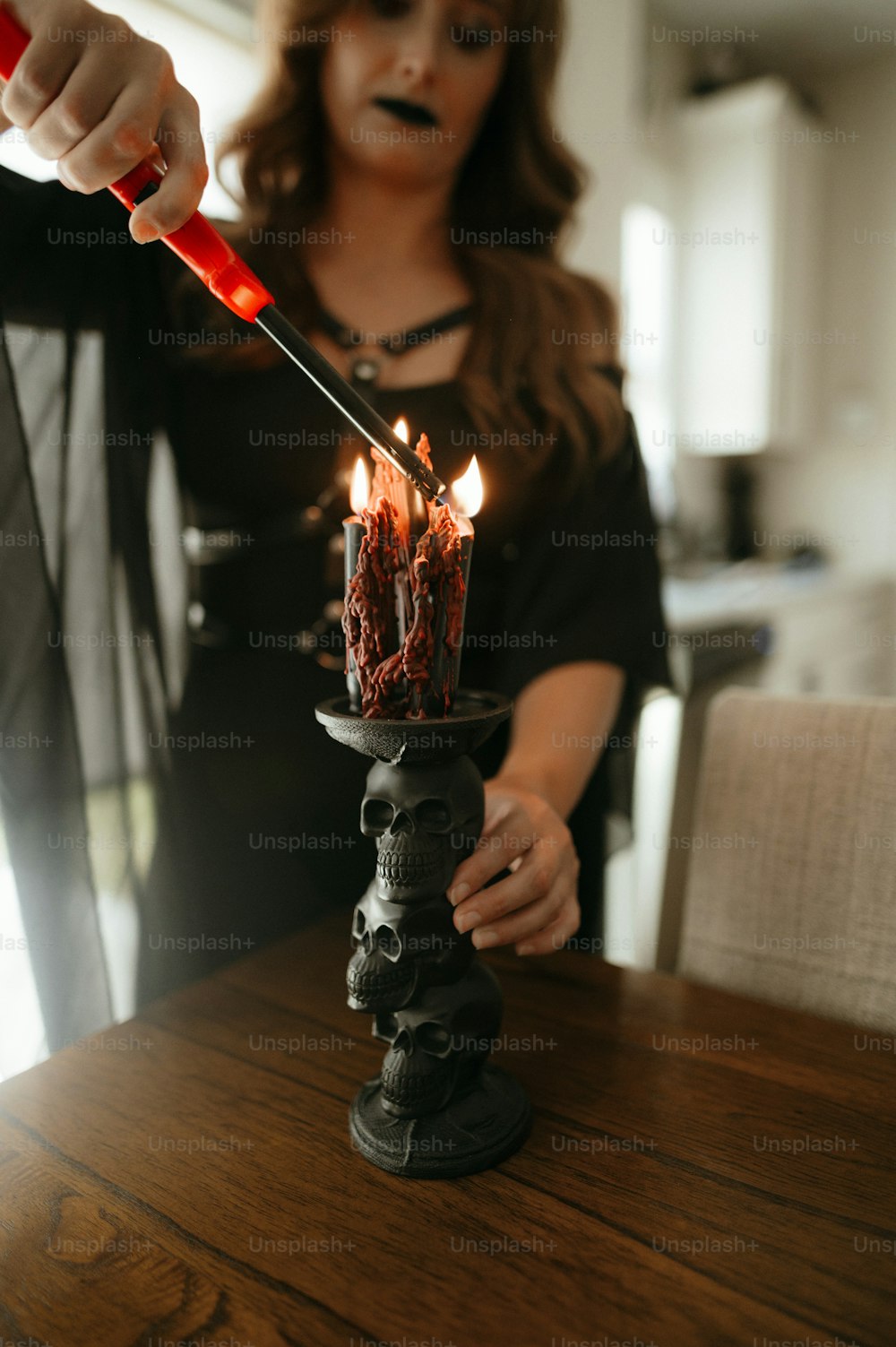 a woman is lighting a candle on a table