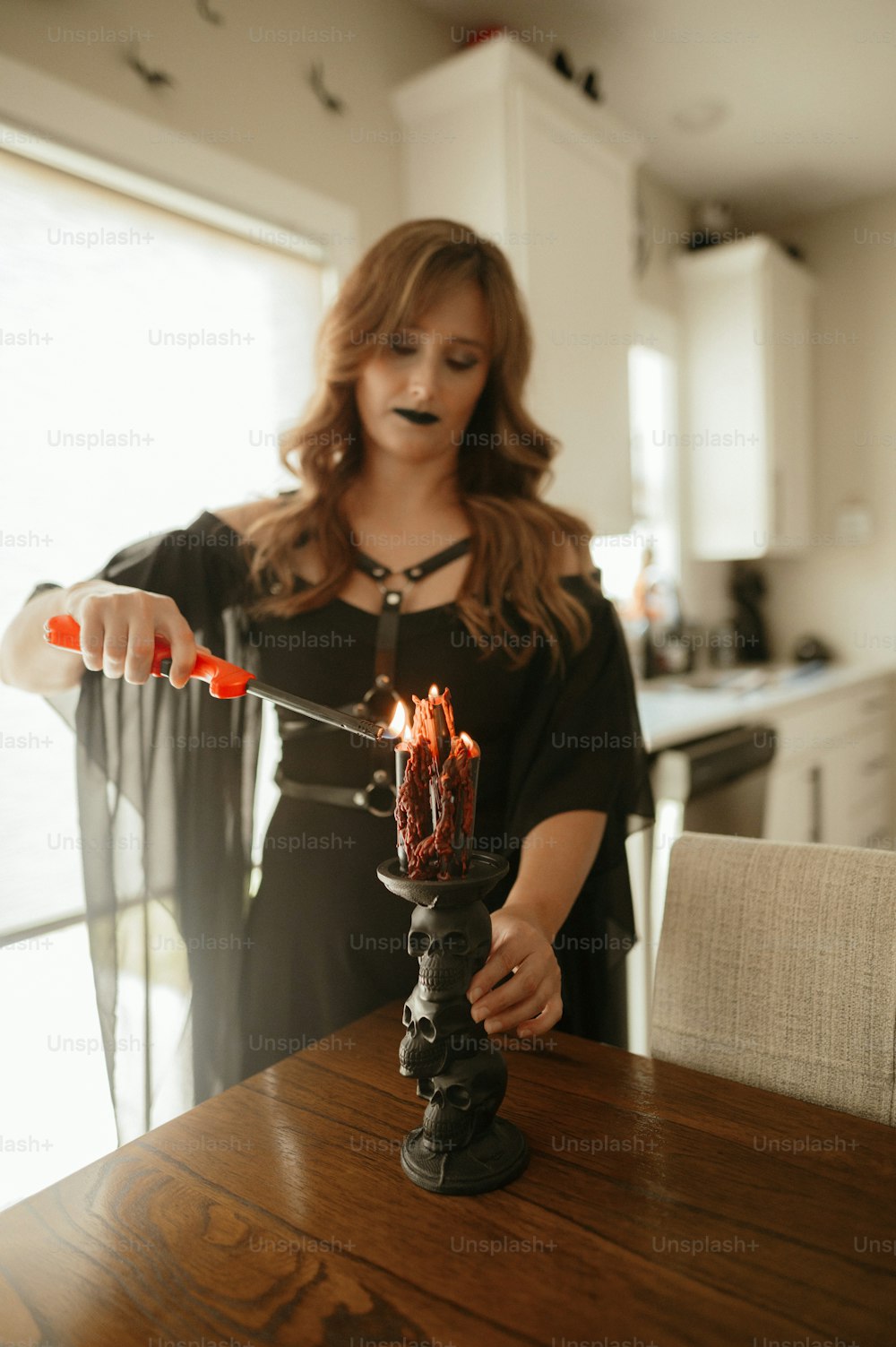 a woman holding a candle on top of a wooden table