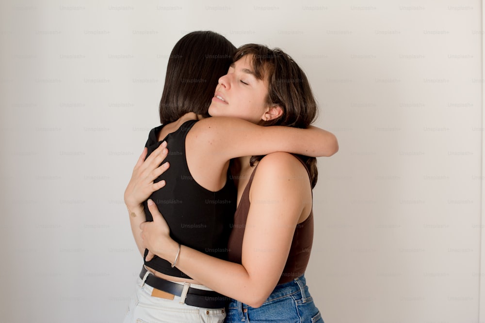 two women hugging each other in a room