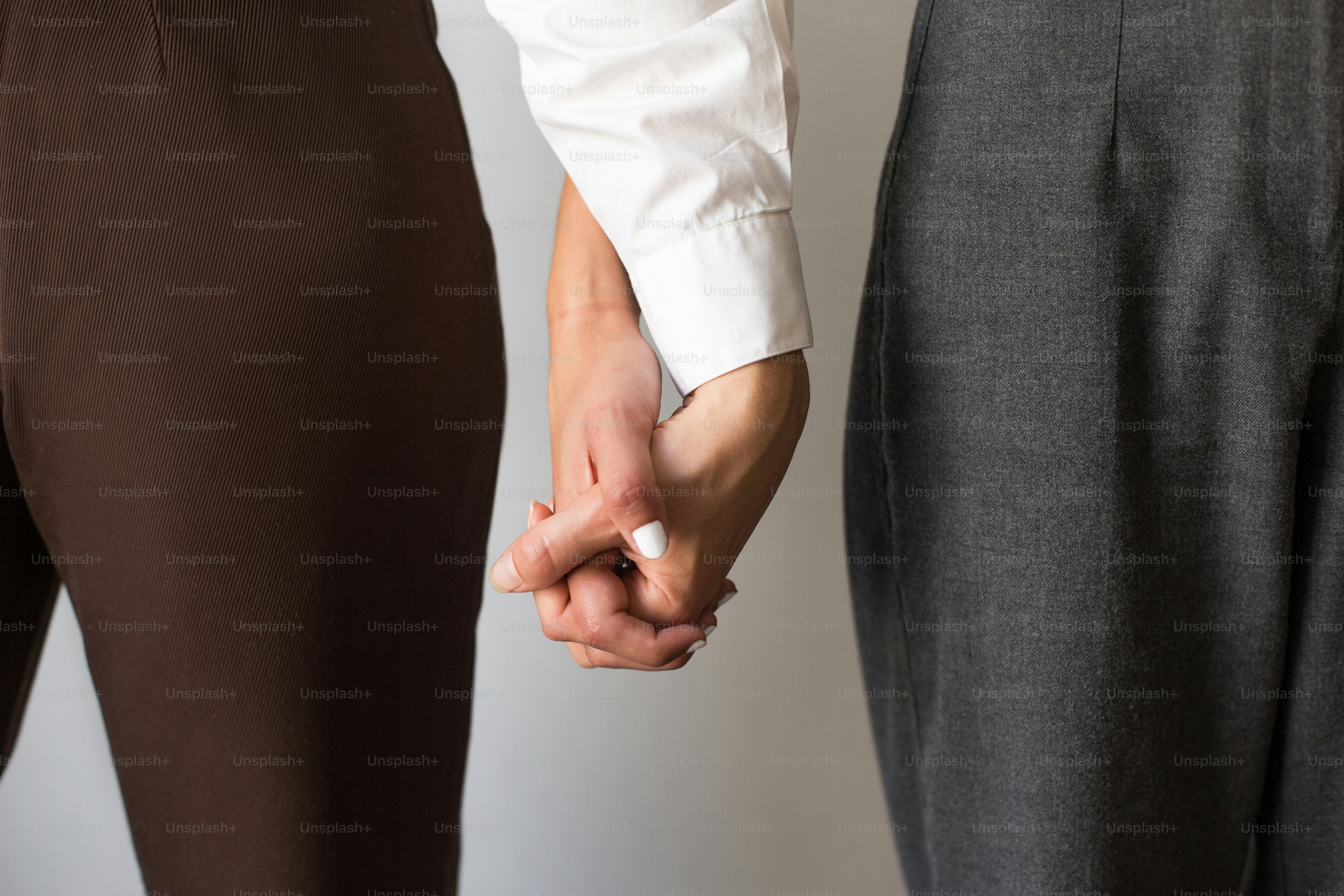 Dos personas tomadas de la mano mientras están de pie una al lado de la otra