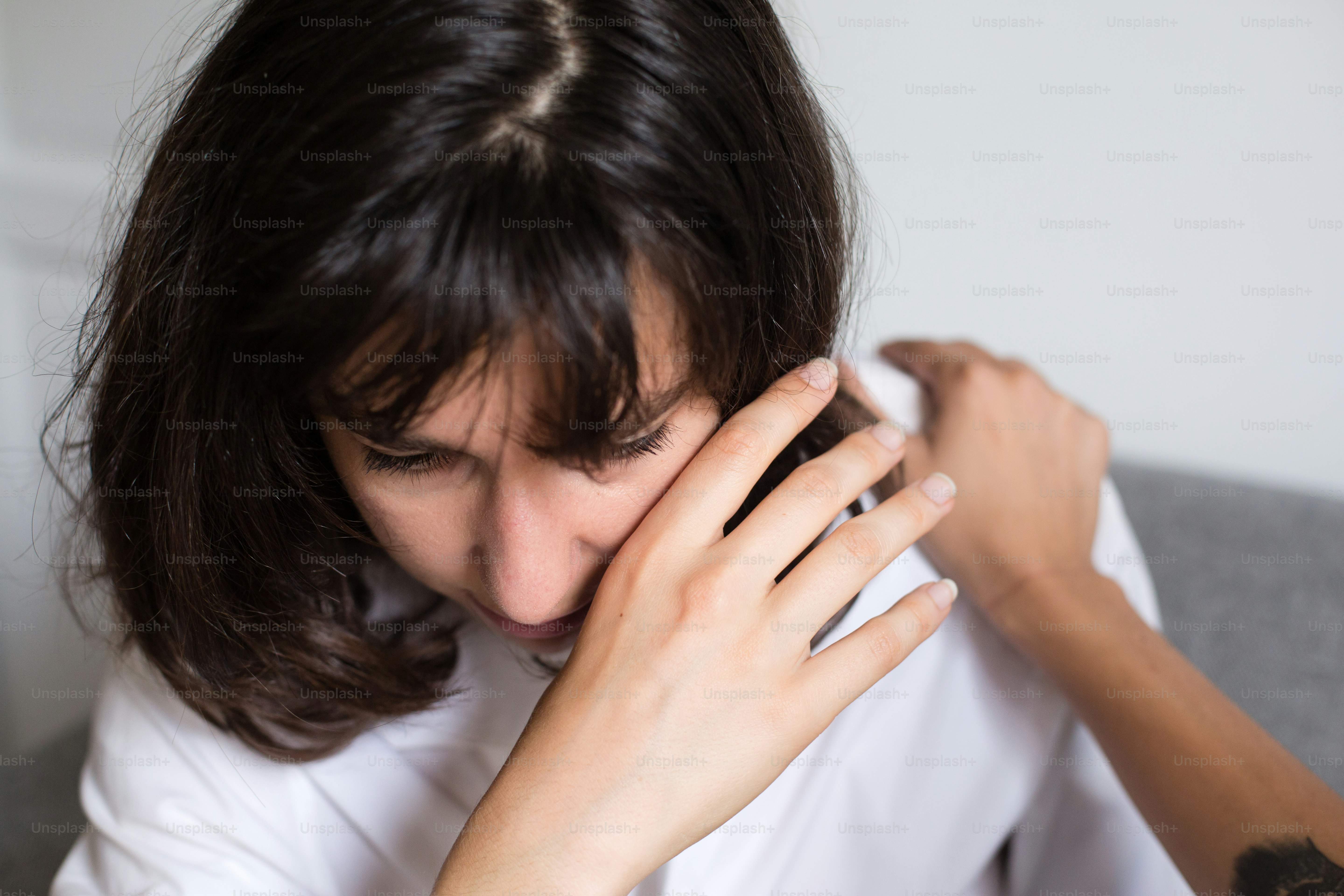 a woman holding her hand to her face