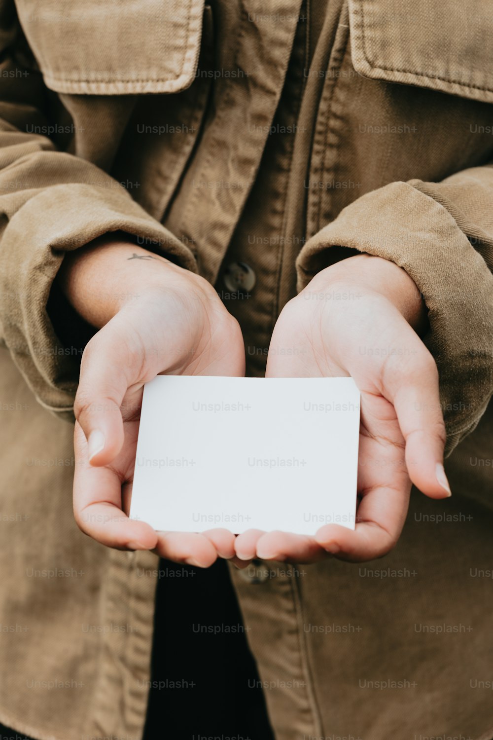 uma pessoa segurando um cartão de visita em suas mãos