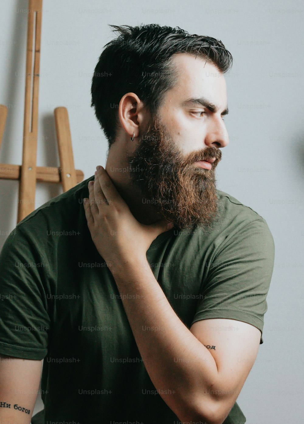 a man with a beard holding his neck