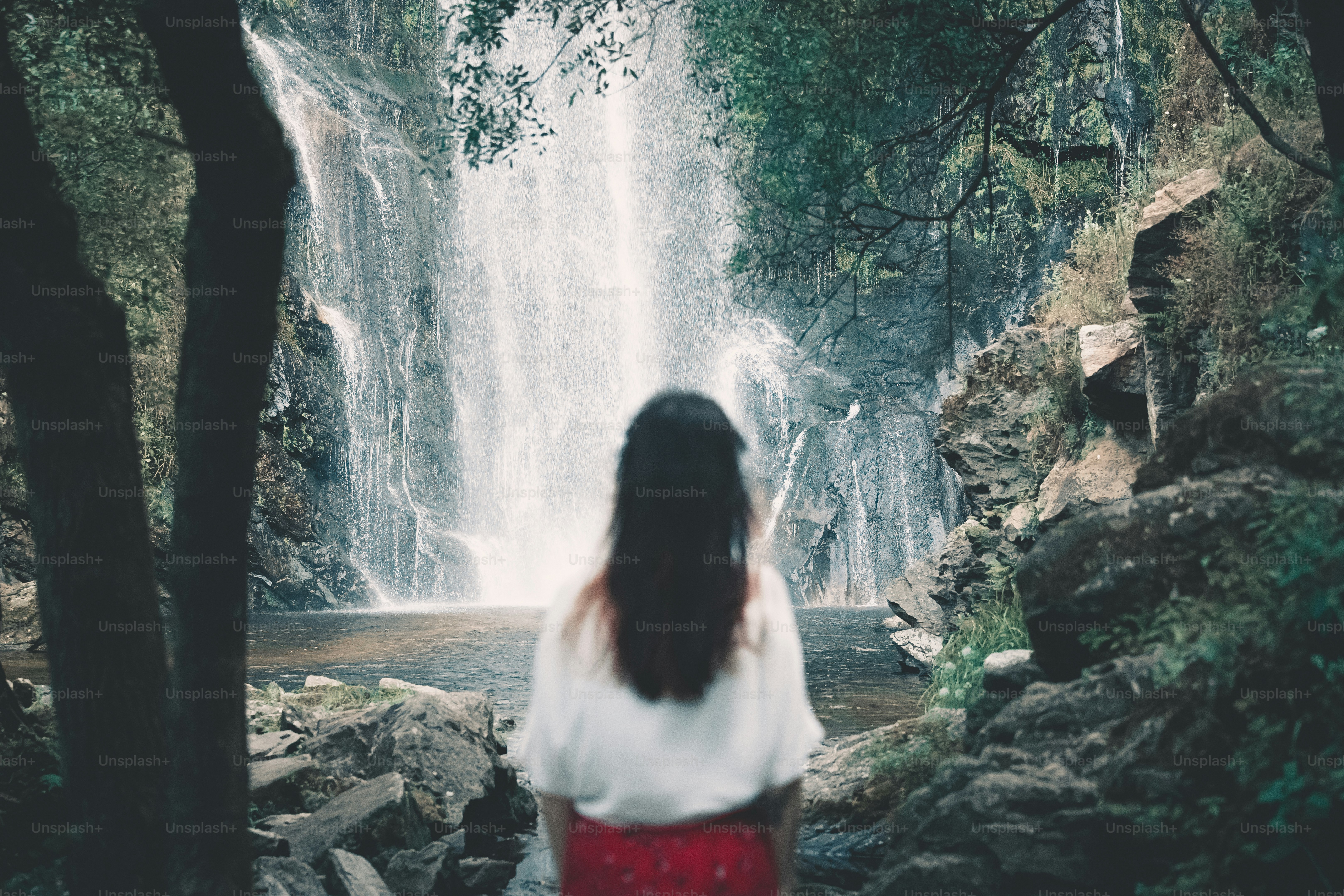 a woman standing in front of a waterfall