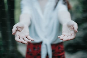 a woman in a white shirt holding out her hands