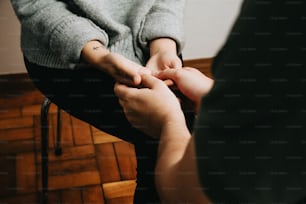 two people sitting on a chair holding hands