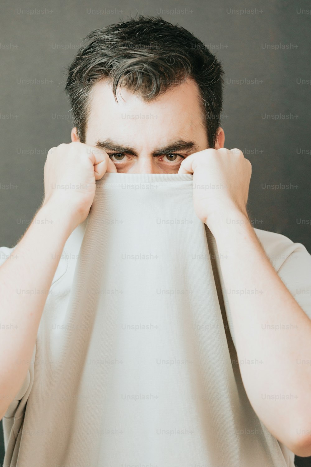 a man covering his face with a white cloth
