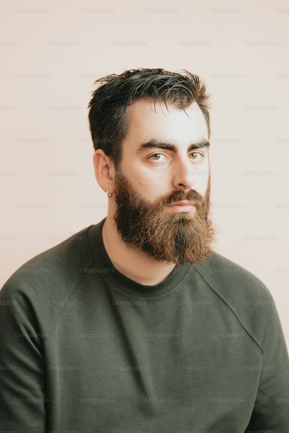 un uomo con la barba e una camicia verde