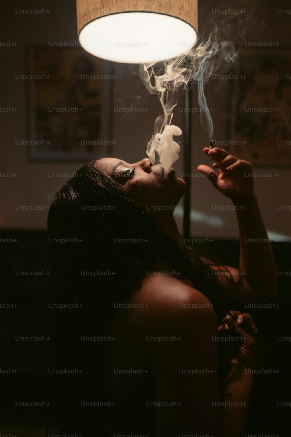 a woman smoking a cigarette in a dark room