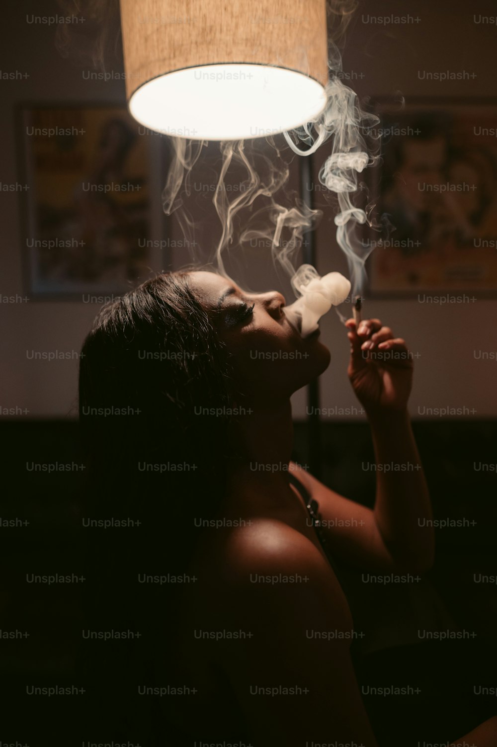 a woman smoking a cigarette under a lamp