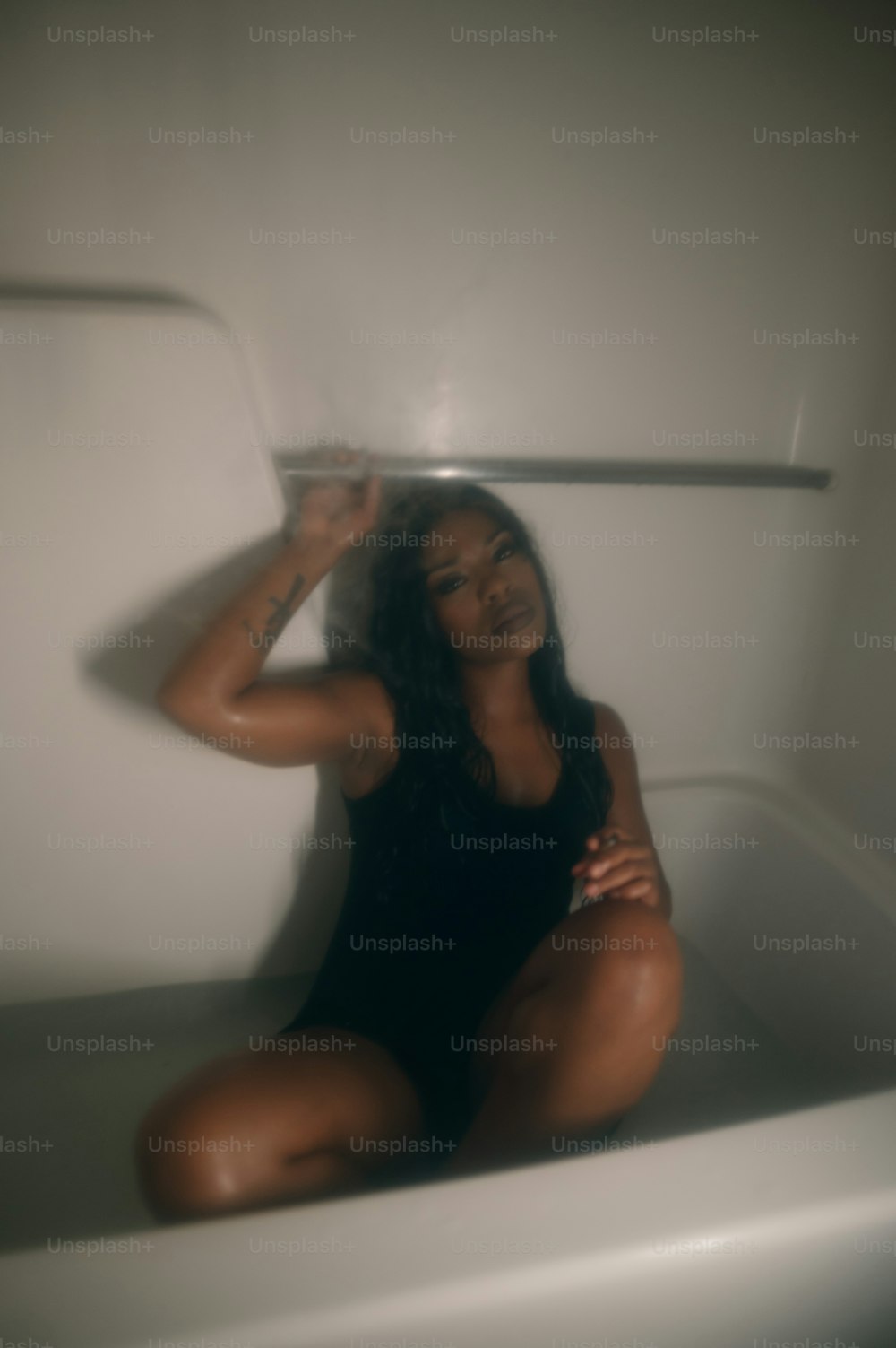 una donna che si siede in una vasca da bagno in un bagno