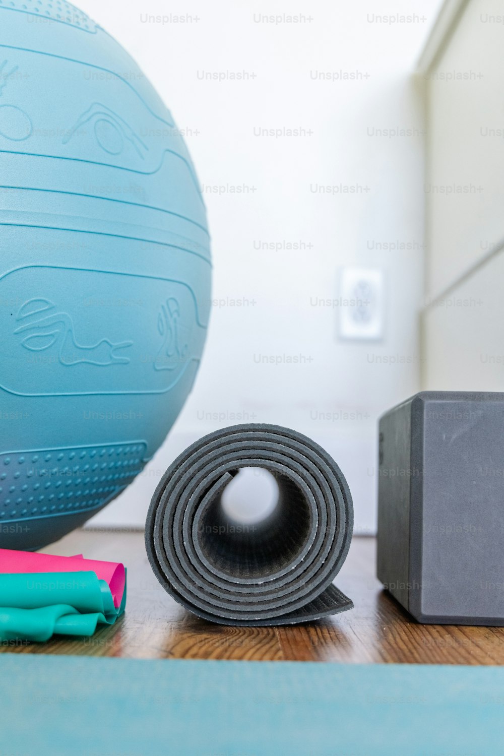 a yoga mat and a yoga ball on a wooden floor