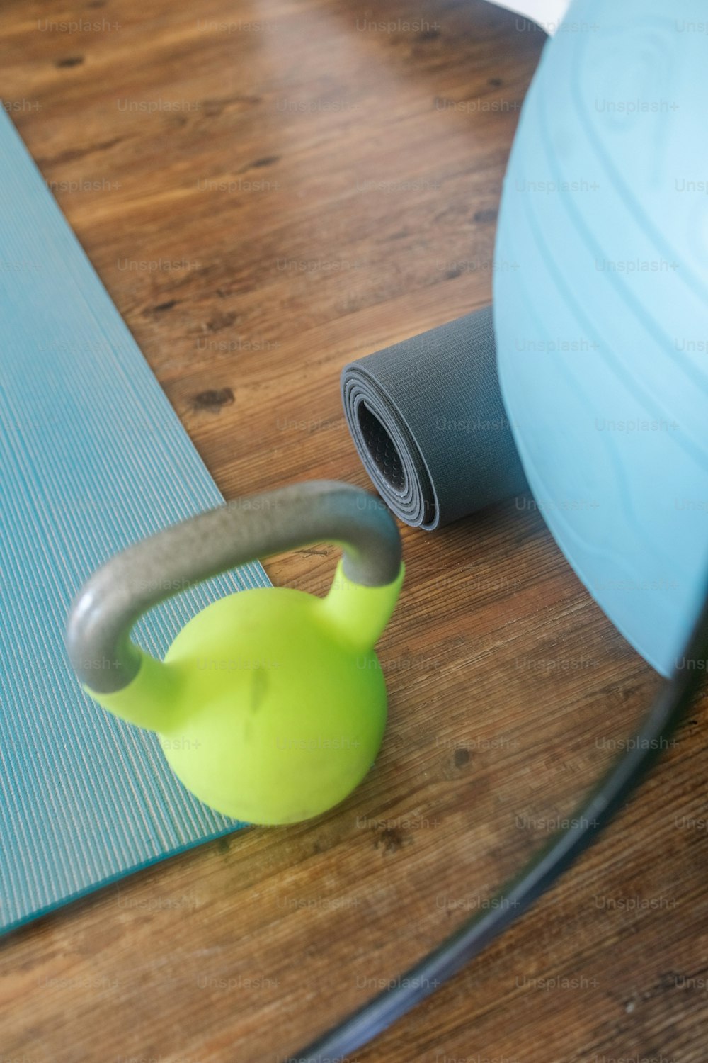 a kettle and a yoga mat on a wooden floor