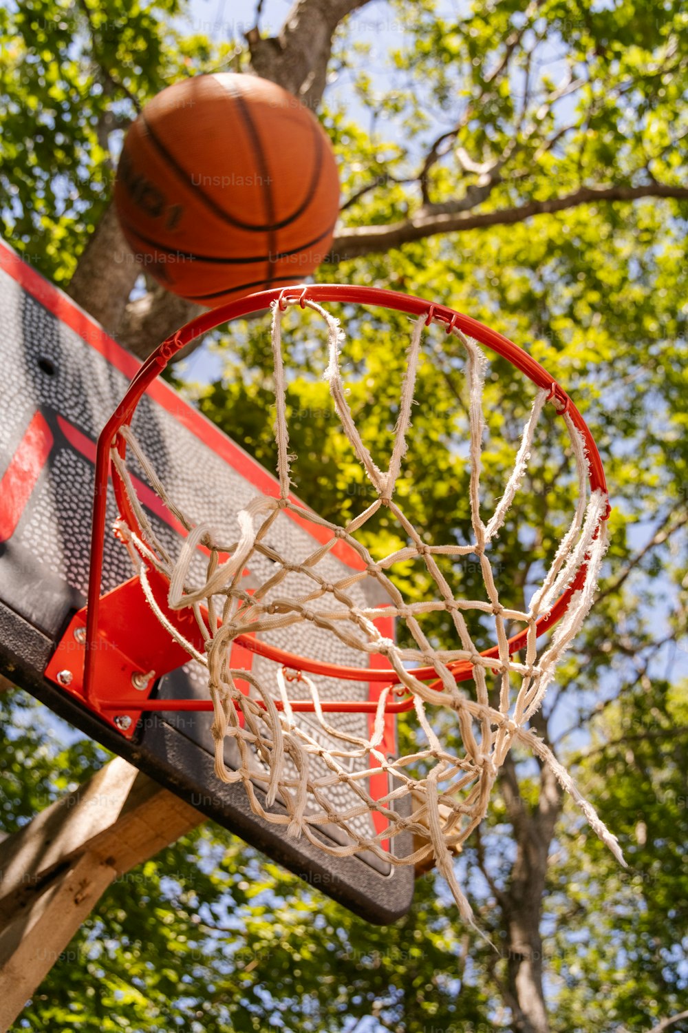 Una pelota de baloncesto atravesando la red de un aro de baloncesto