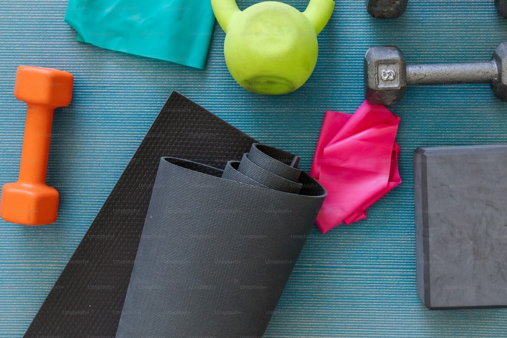a gym mat with dumbs, a towel, a towel, and a rubber