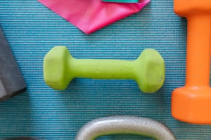 a close up of a gym mat with dumbs, a pair of scissors and