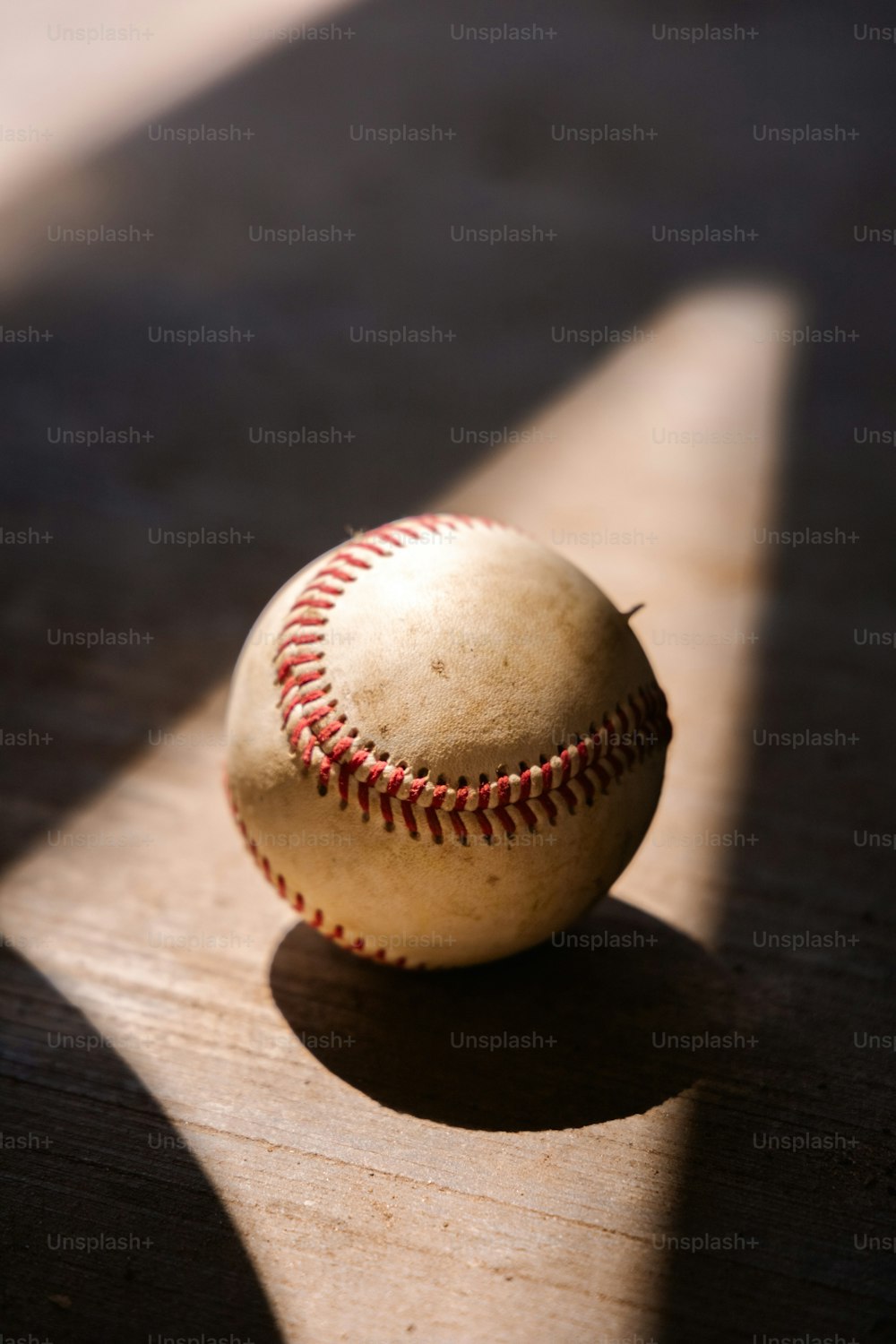 Una pelota de béisbol sentada encima de una mesa de madera