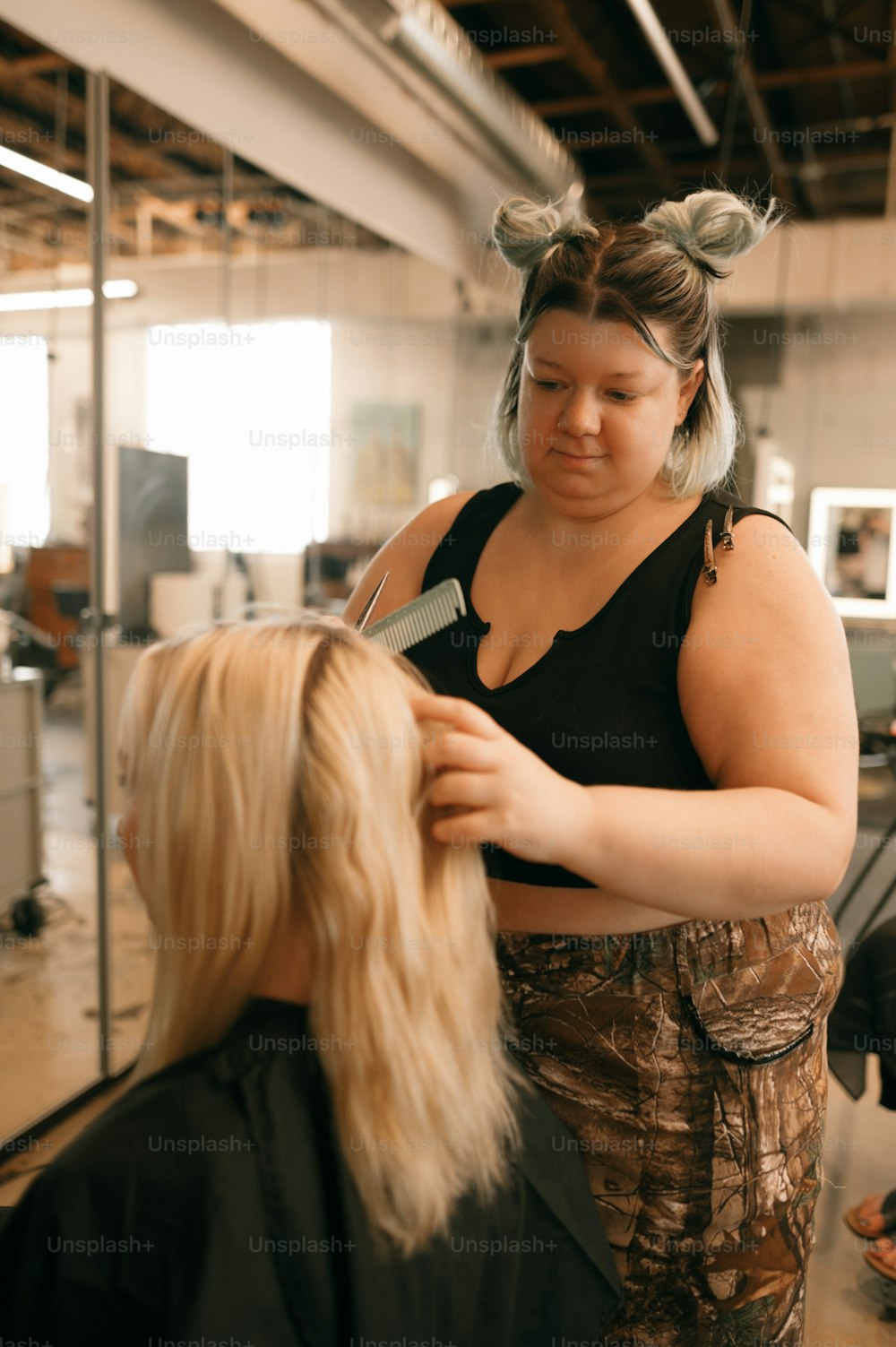 a woman cutting another woman's hair in a salon