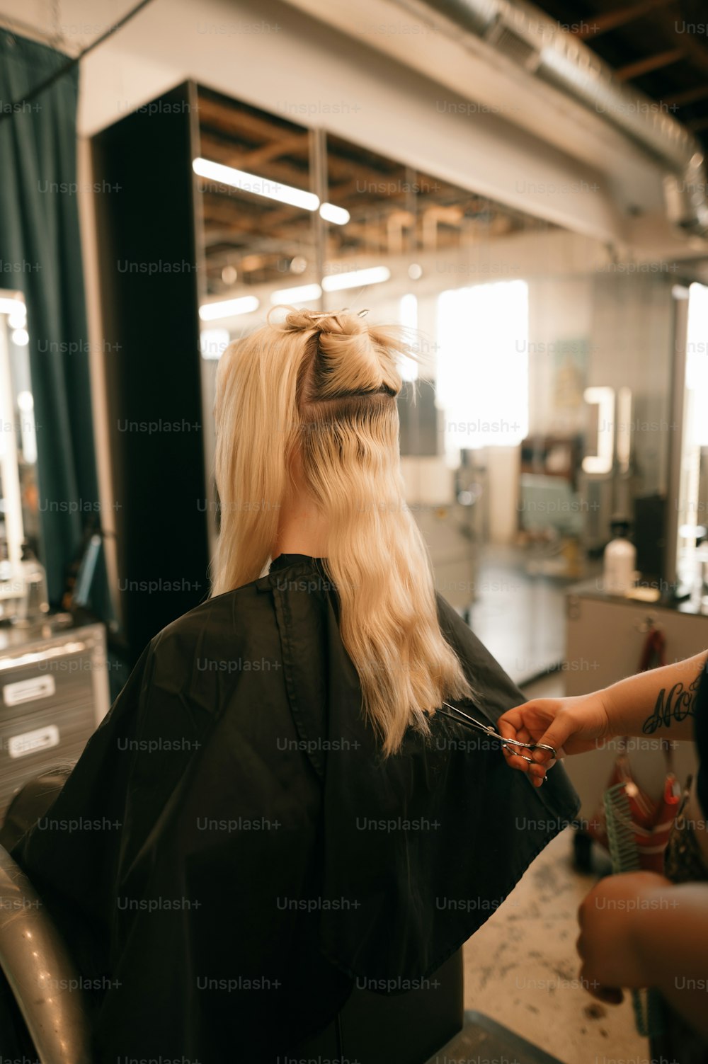 a woman getting her hair cut at a salon