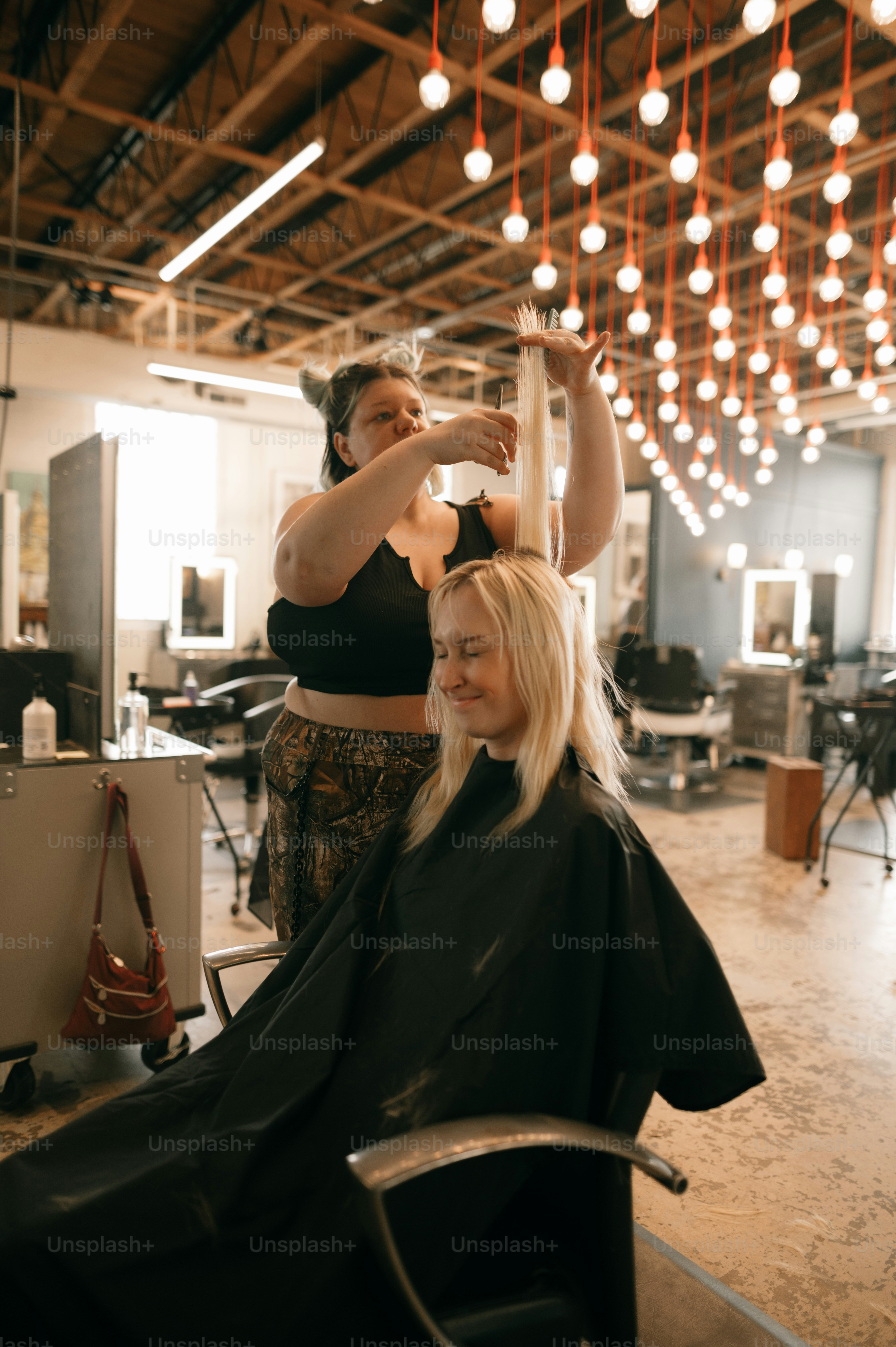 Eine Frau, die sich von einem Friseur die Haare schneiden lässt