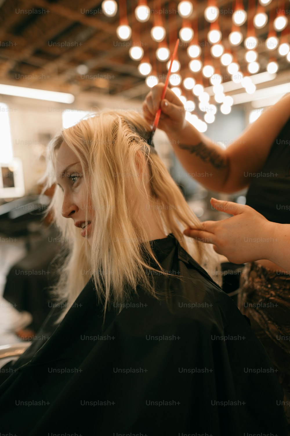 a woman getting her hair cut by a hair stylist