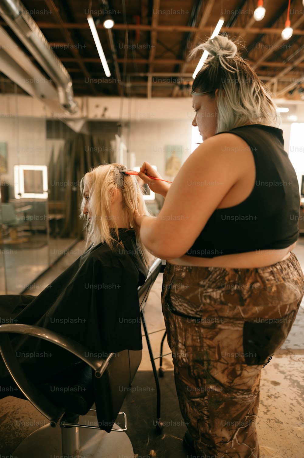 Eine Frau, die einer anderen Frau in einem Salon die Haare schneidet