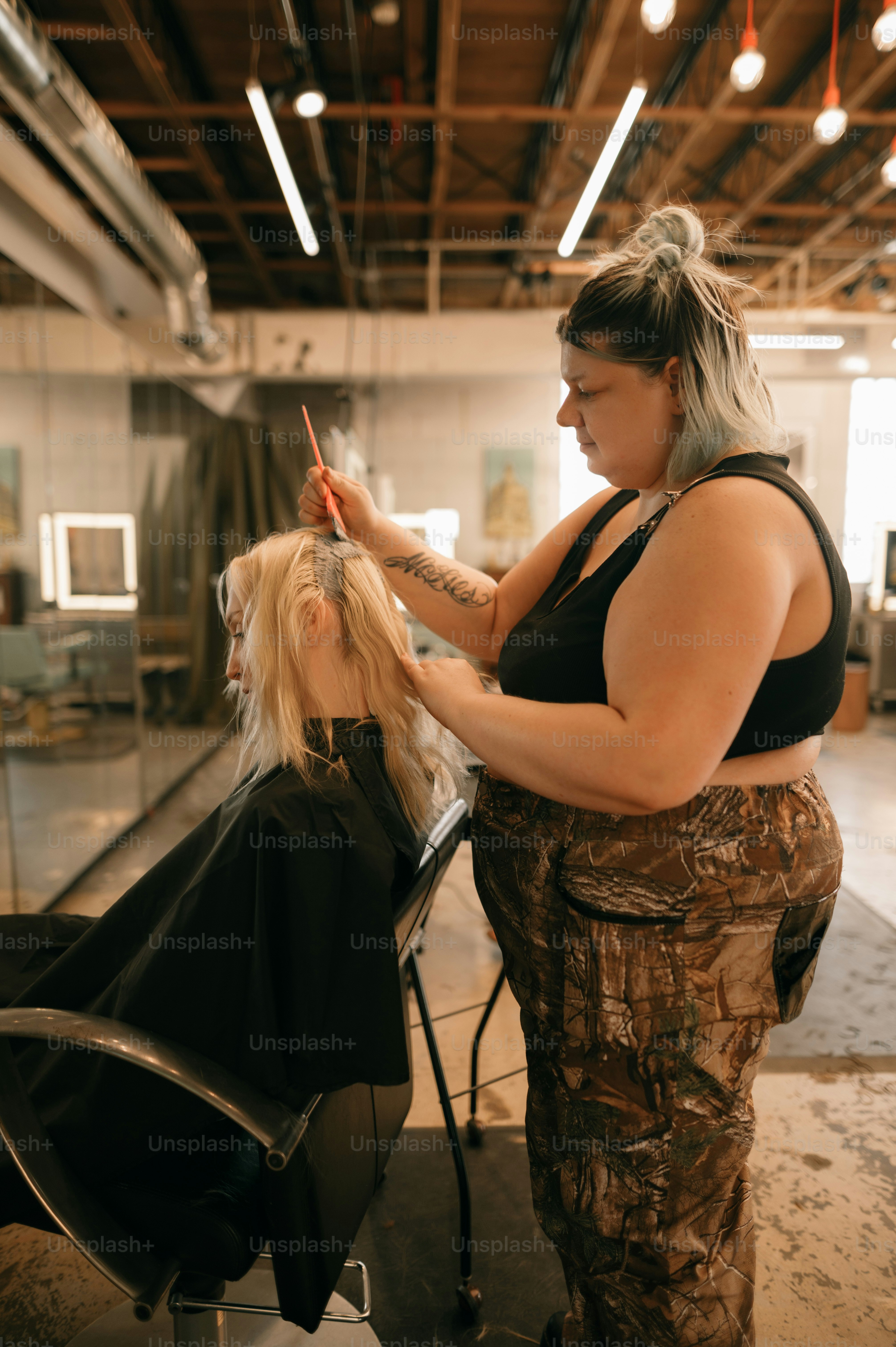 Eine Frau, die einer anderen Frau in einem Salon die Haare schneidet