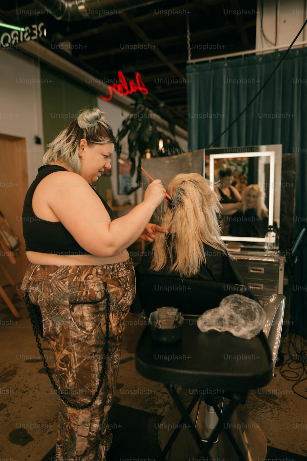 uma mulher cortando o cabelo em um salão