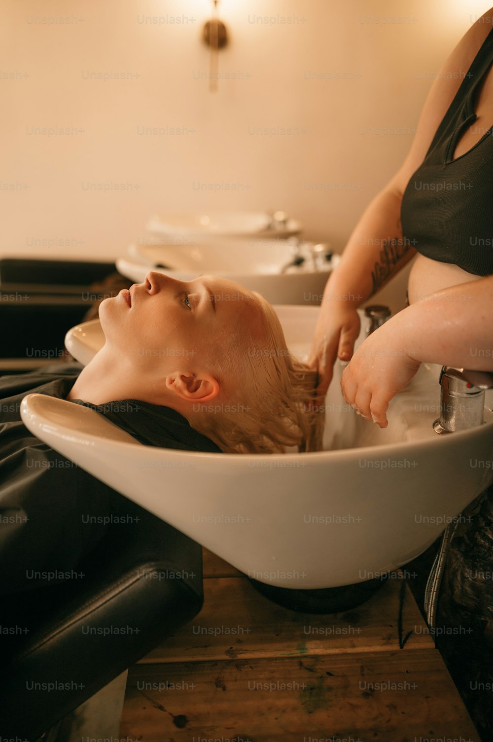 a woman getting her hair washed in a bowl