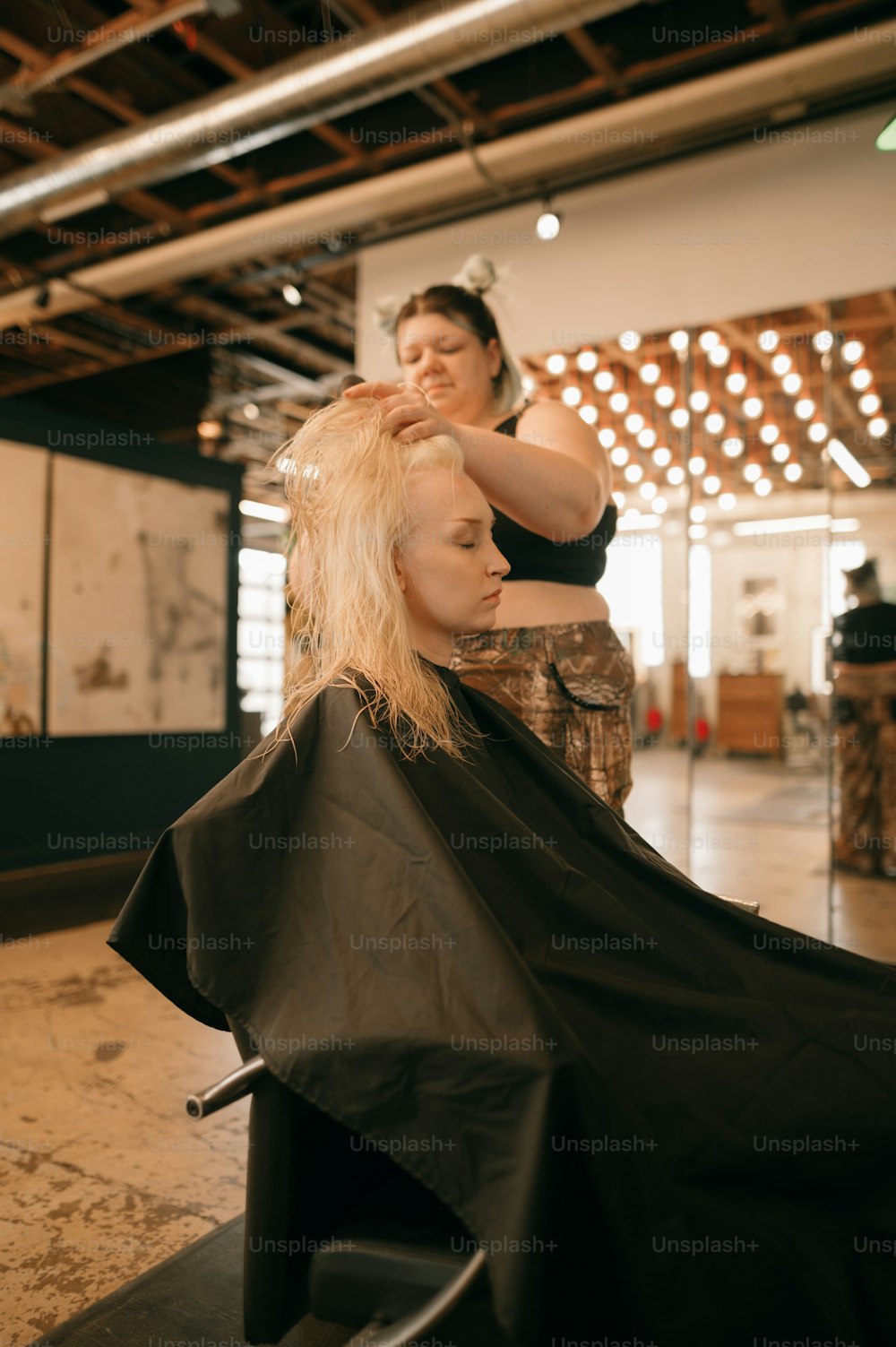Una donna che taglia i capelli di un'altra donna in un salone