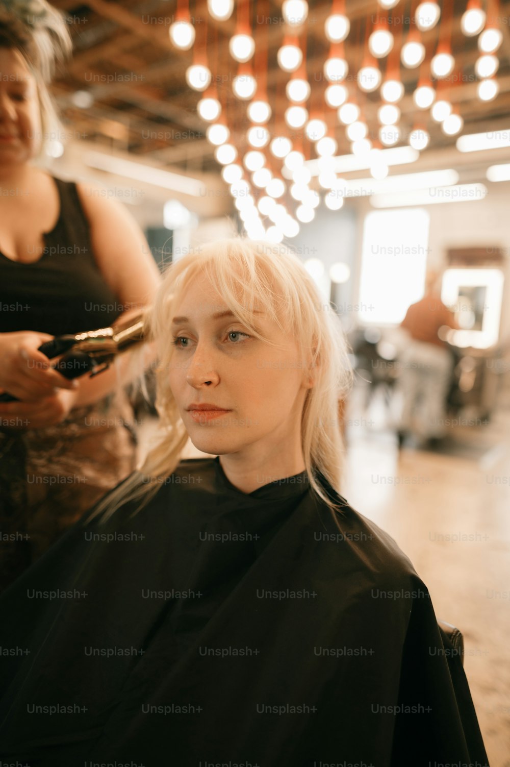 a woman getting her hair cut at a salon