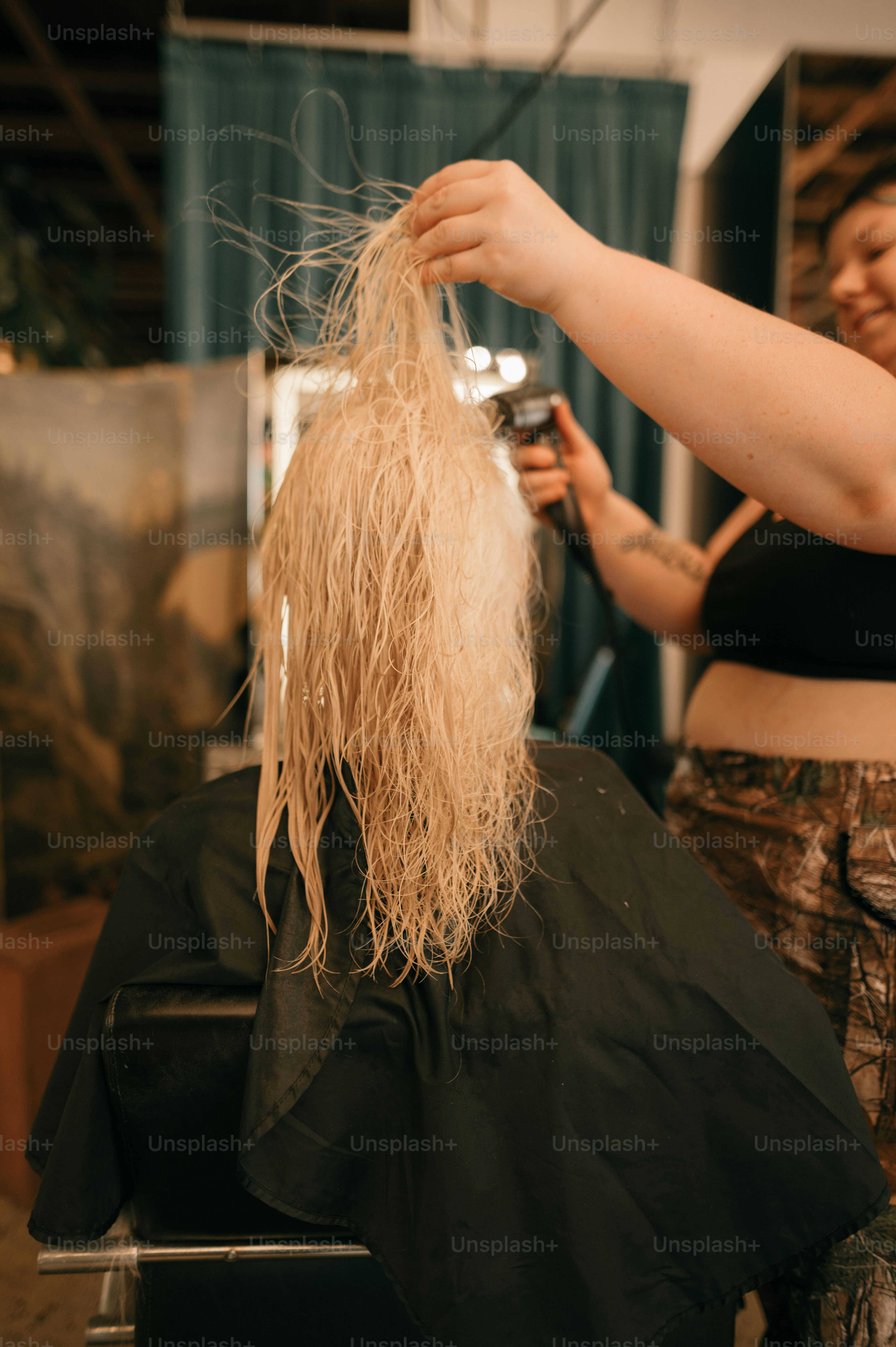 a woman cutting another woman's hair in a salon