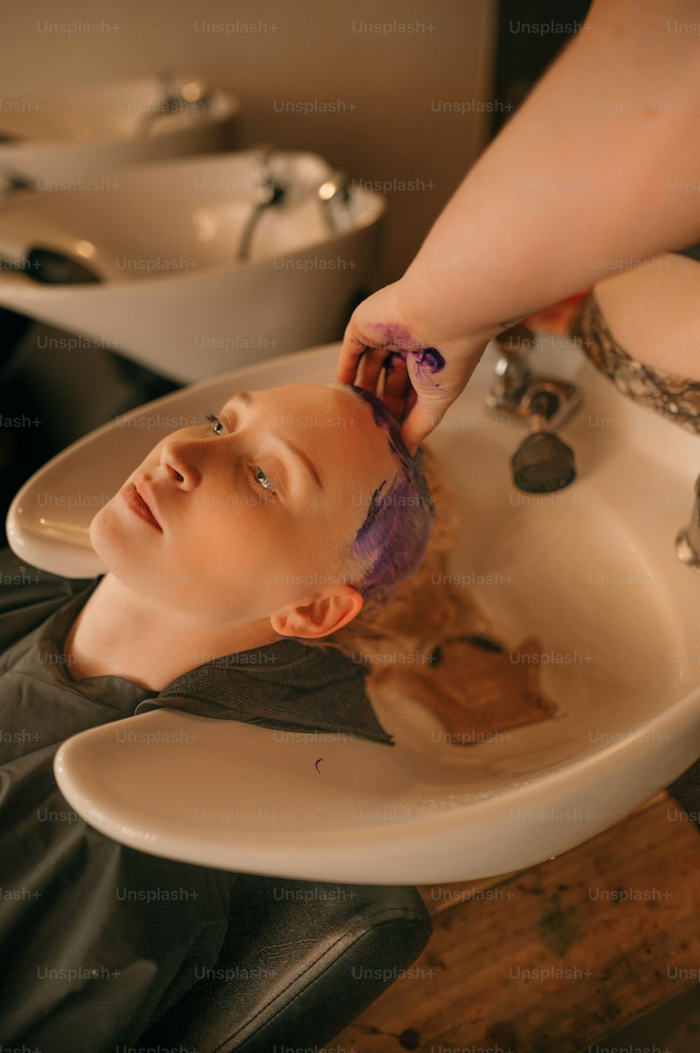 a woman is getting her hair washed in a sink