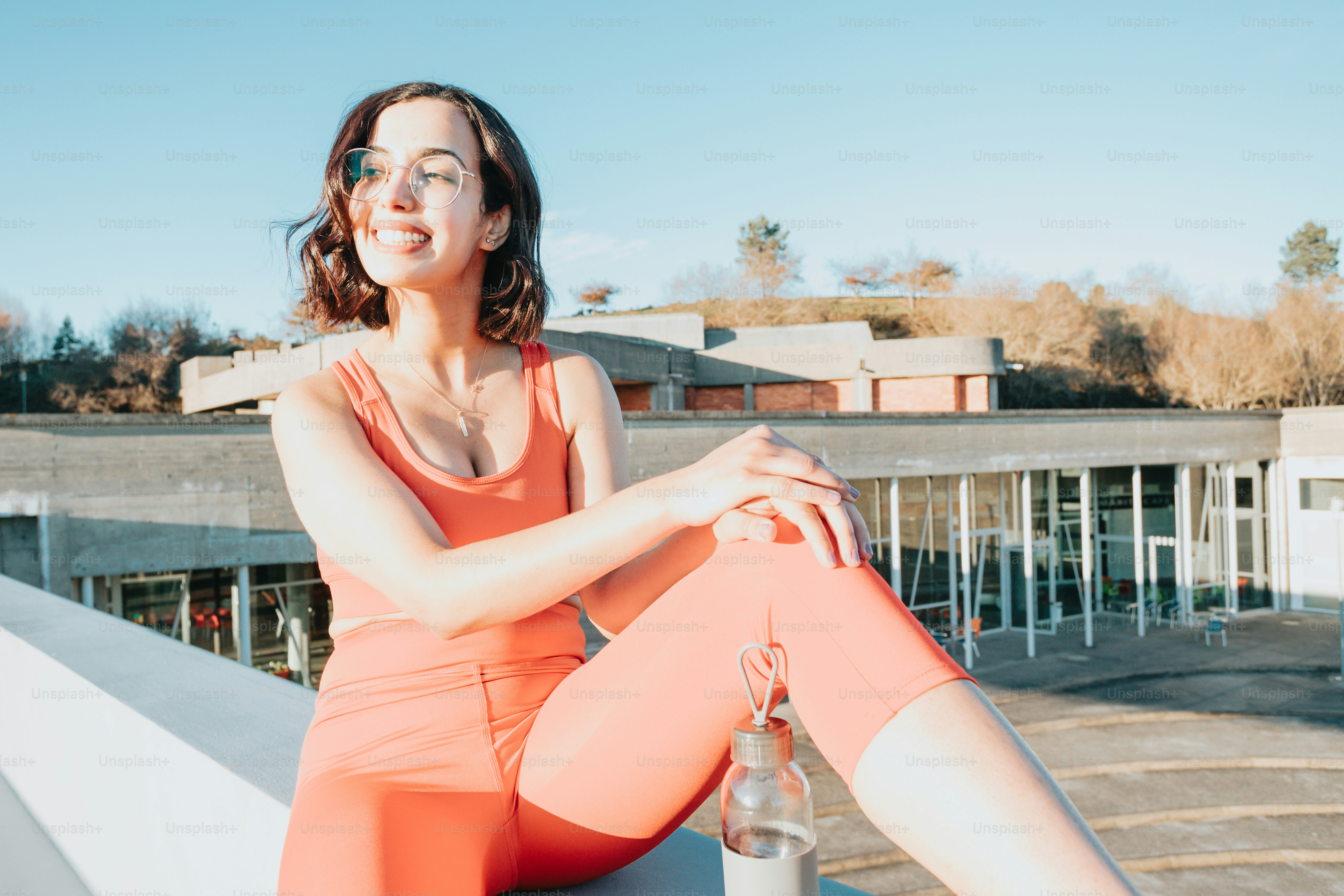a woman sitting on a ledge with her legs crossed