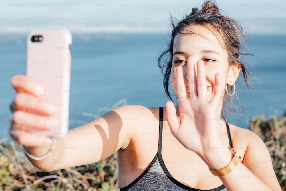 Una mujer tomándose una selfie con su teléfono celular