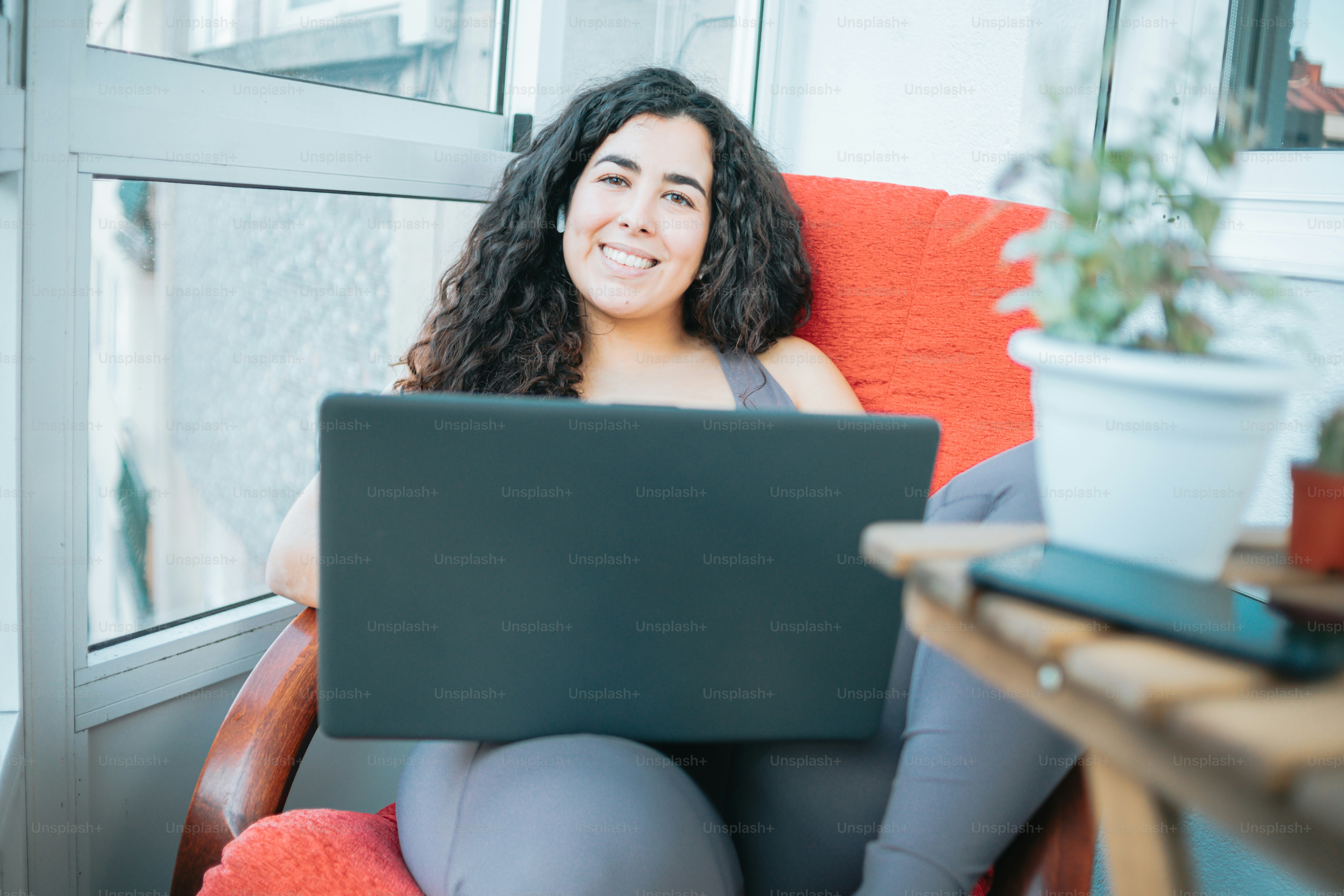 a woman sitting in a chair with a laptop