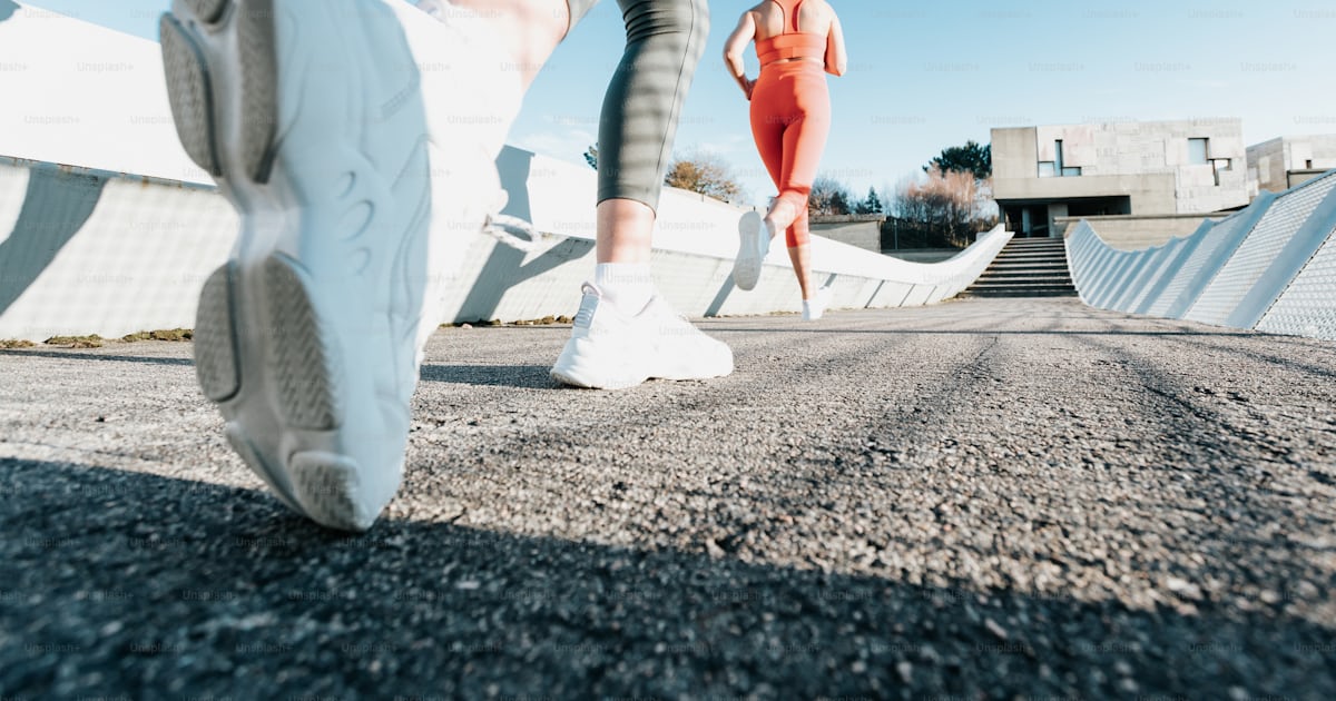 A woman running down a street next to a ramp photo – Jogging Image on ...