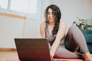 Una mujer sentada en el suelo con una computadora portátil