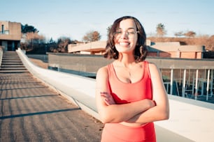 Una mujer con un vestido rojo de pie con los brazos cruzados