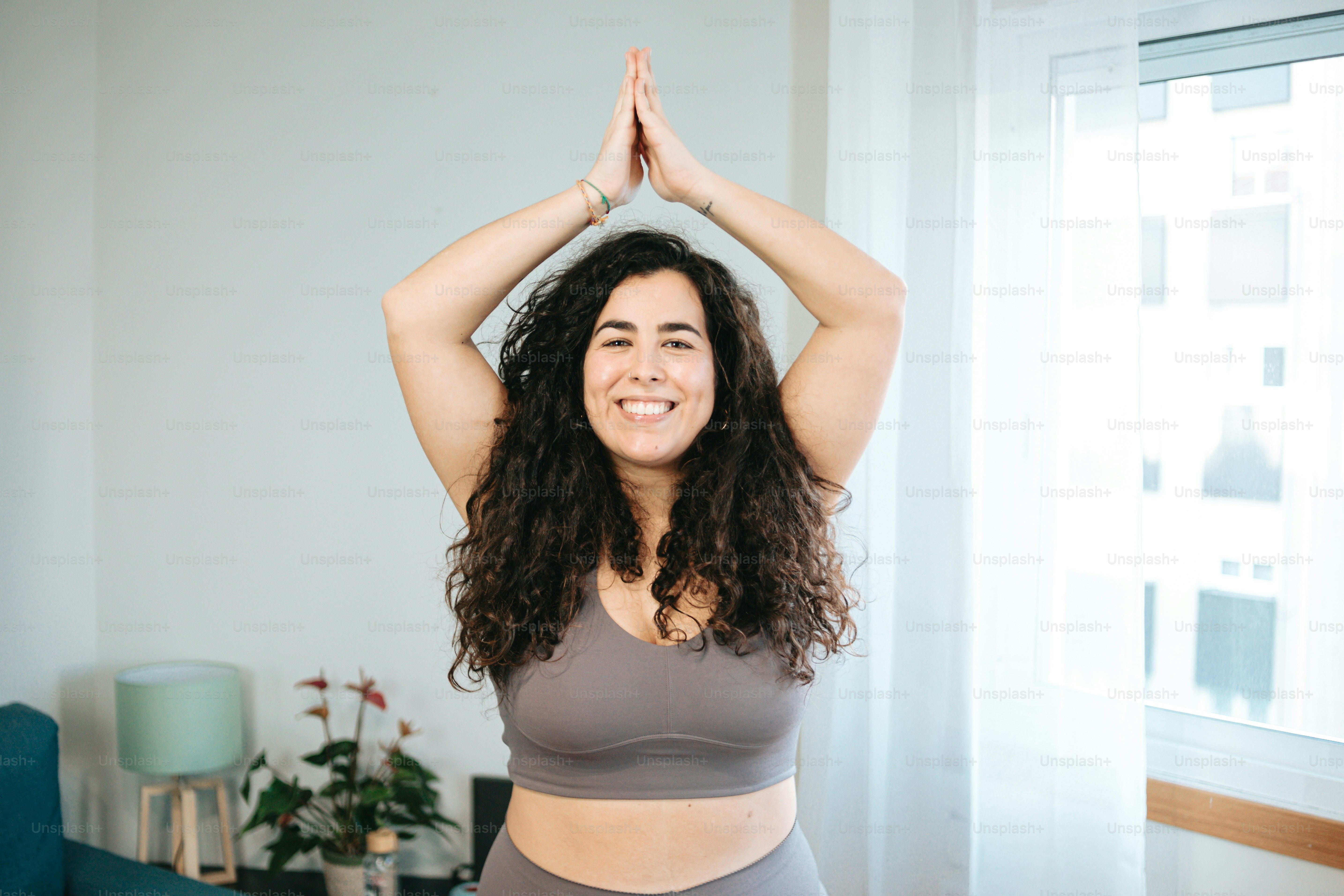 Una donna sta facendo yoga nel suo salotto