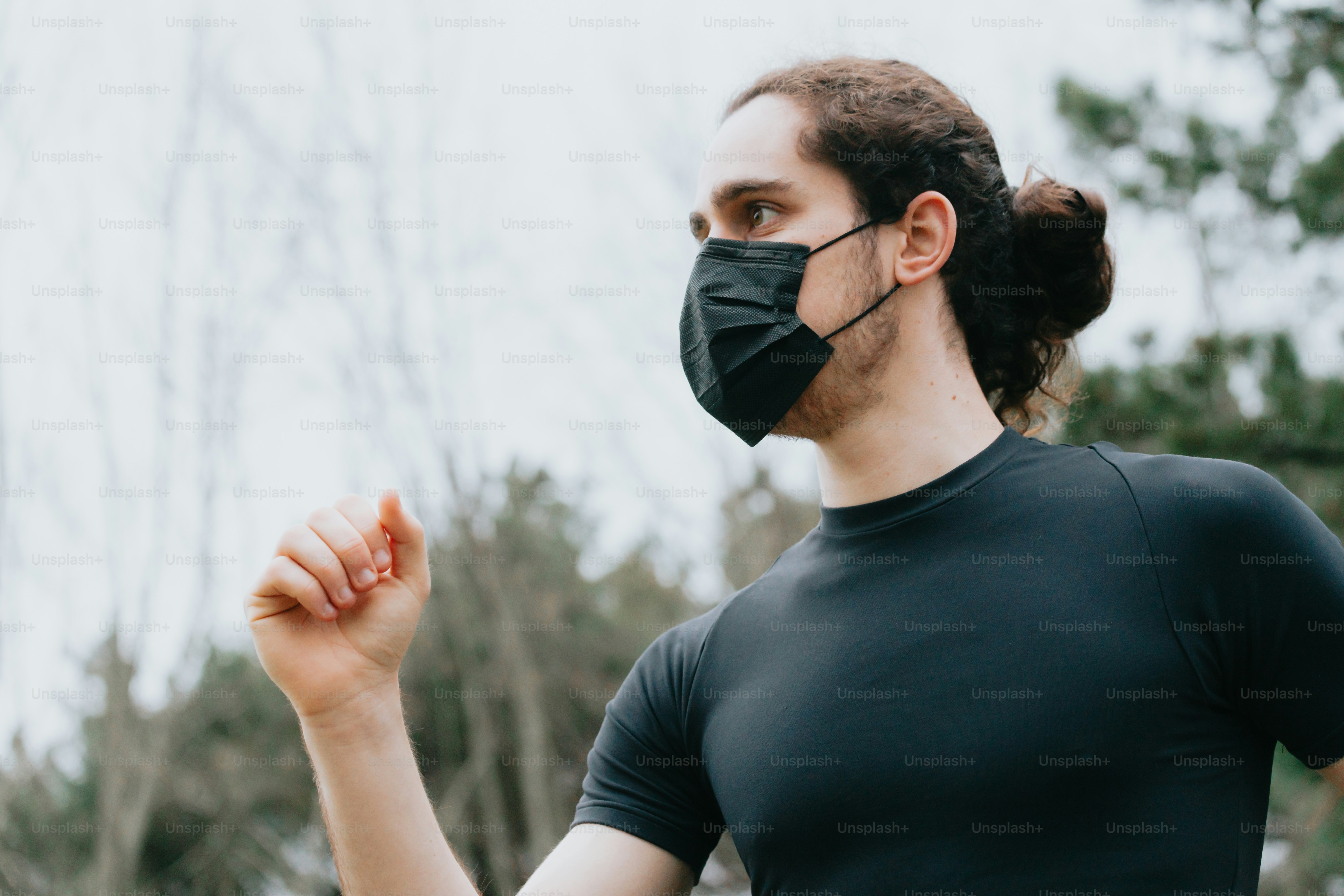 eine Frau, die eine schwarze Gesichtsmaske und ein schwarzes T-Shirt trägt