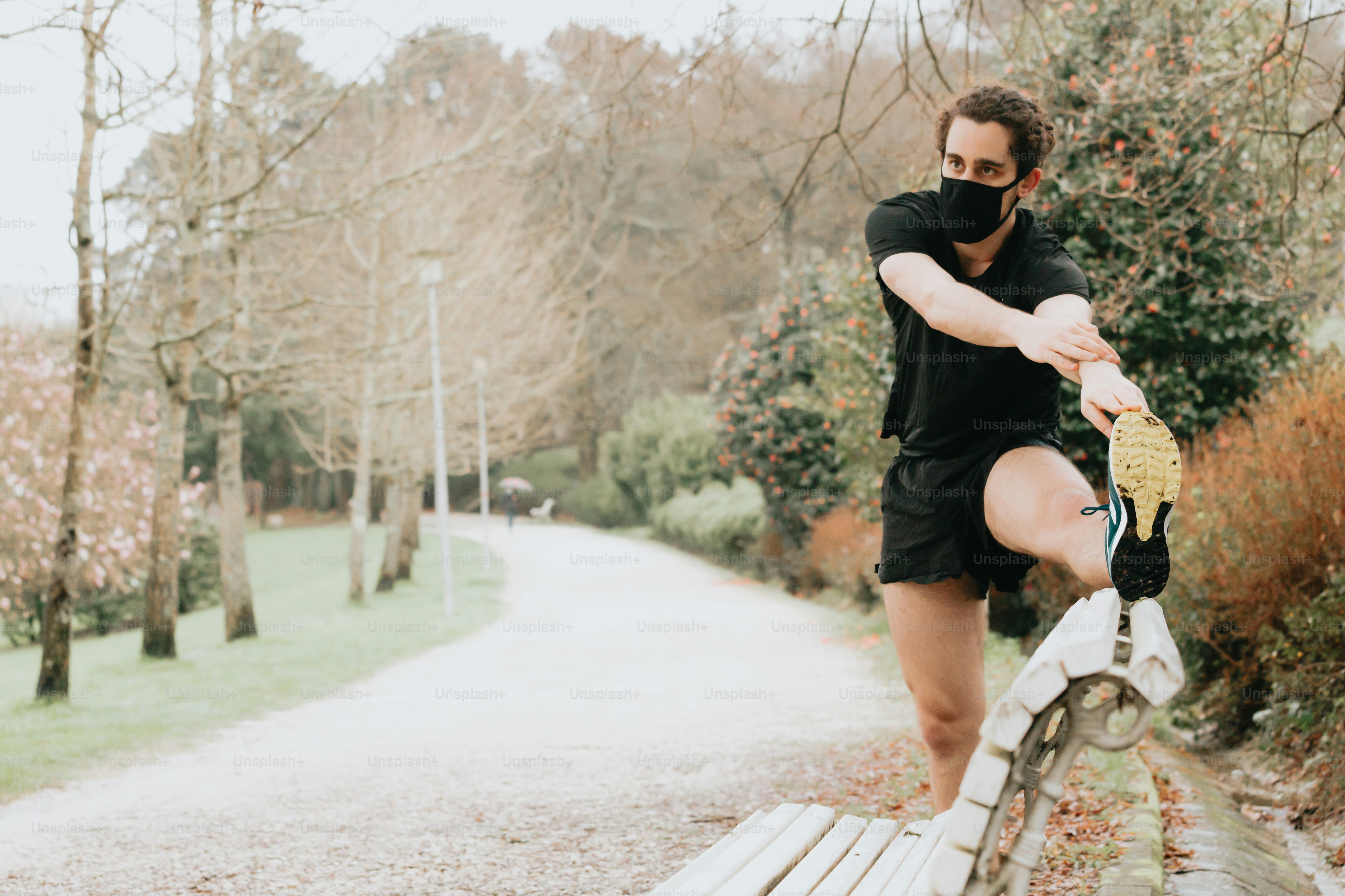 a man wearing a face mask standing on a bench