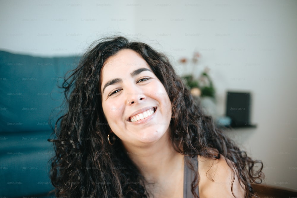 a woman with long curly hair smiling at the camera