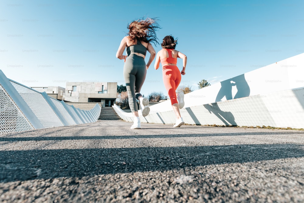 a couple of women running across a street