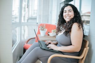 a woman sitting in a chair with a laptop