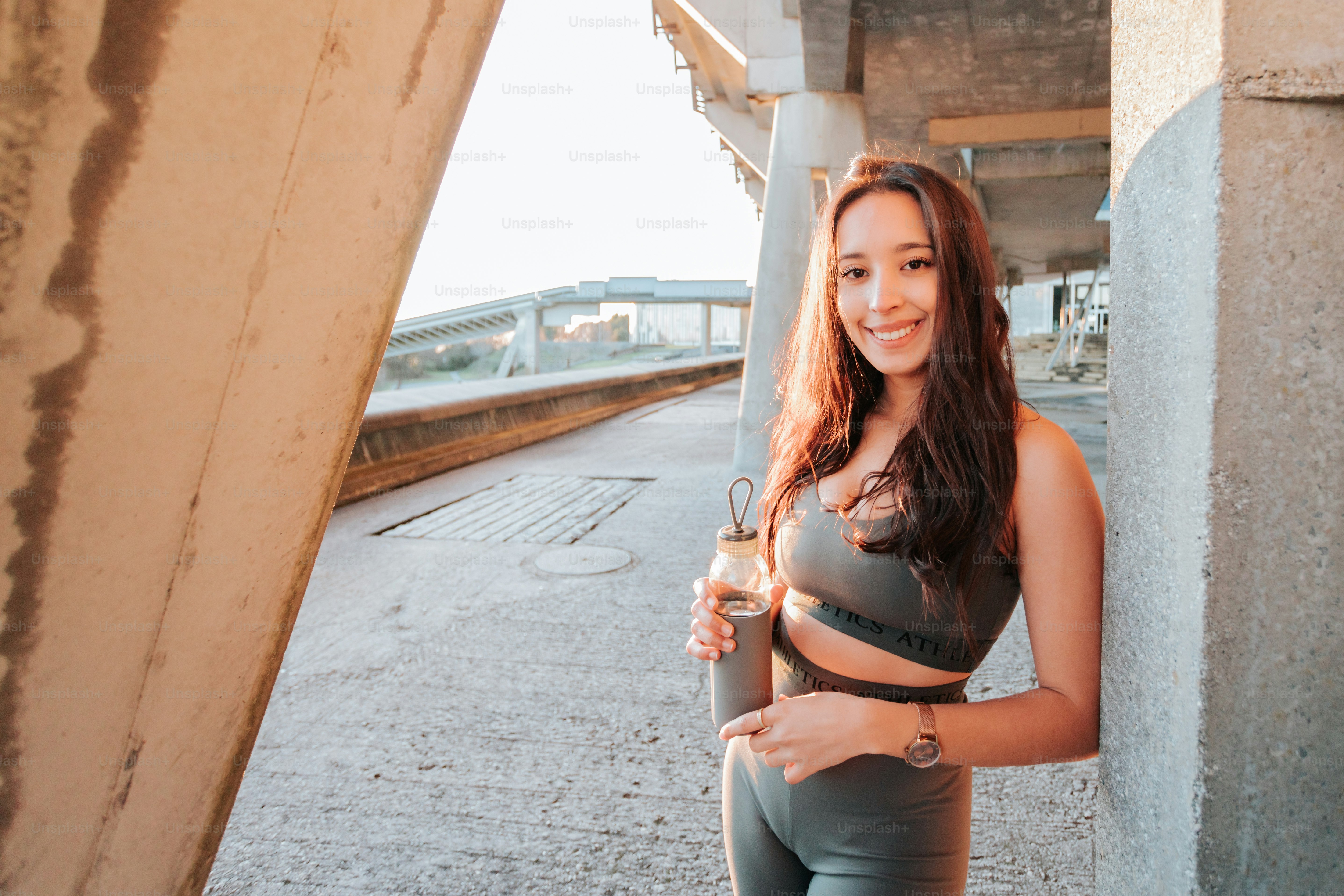 a woman holding a wine glass standing next to a wall