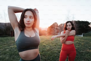 two women in sports bras standing in a field